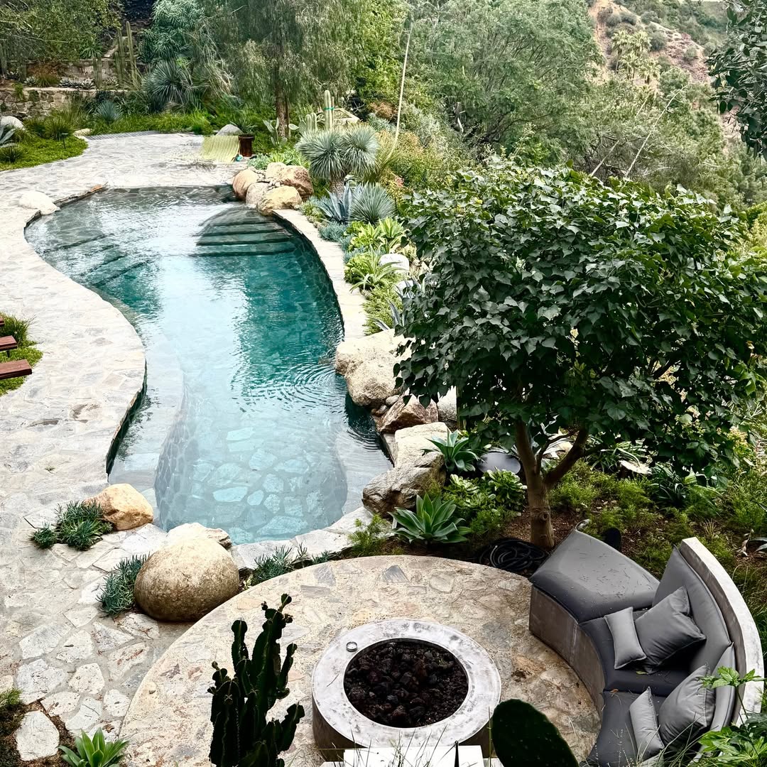 Flagstone fire pit beside a naturalistic pool